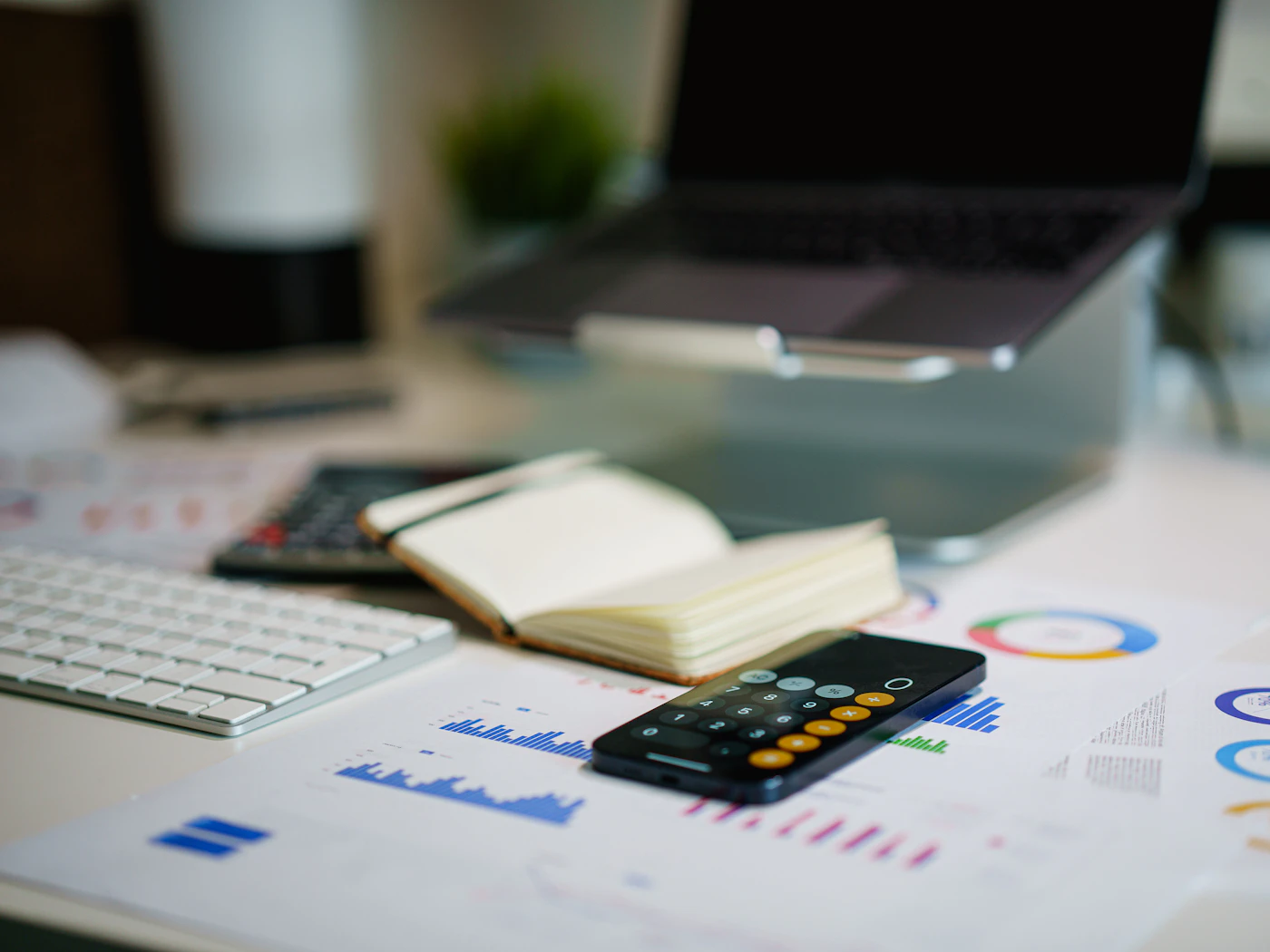 Graphiques financiers, calculatrice et carnet sur un bureau